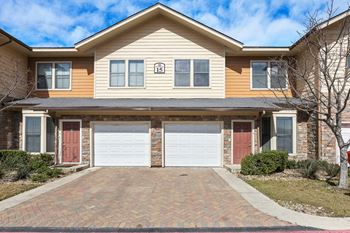 A house with two garage doors in front of it